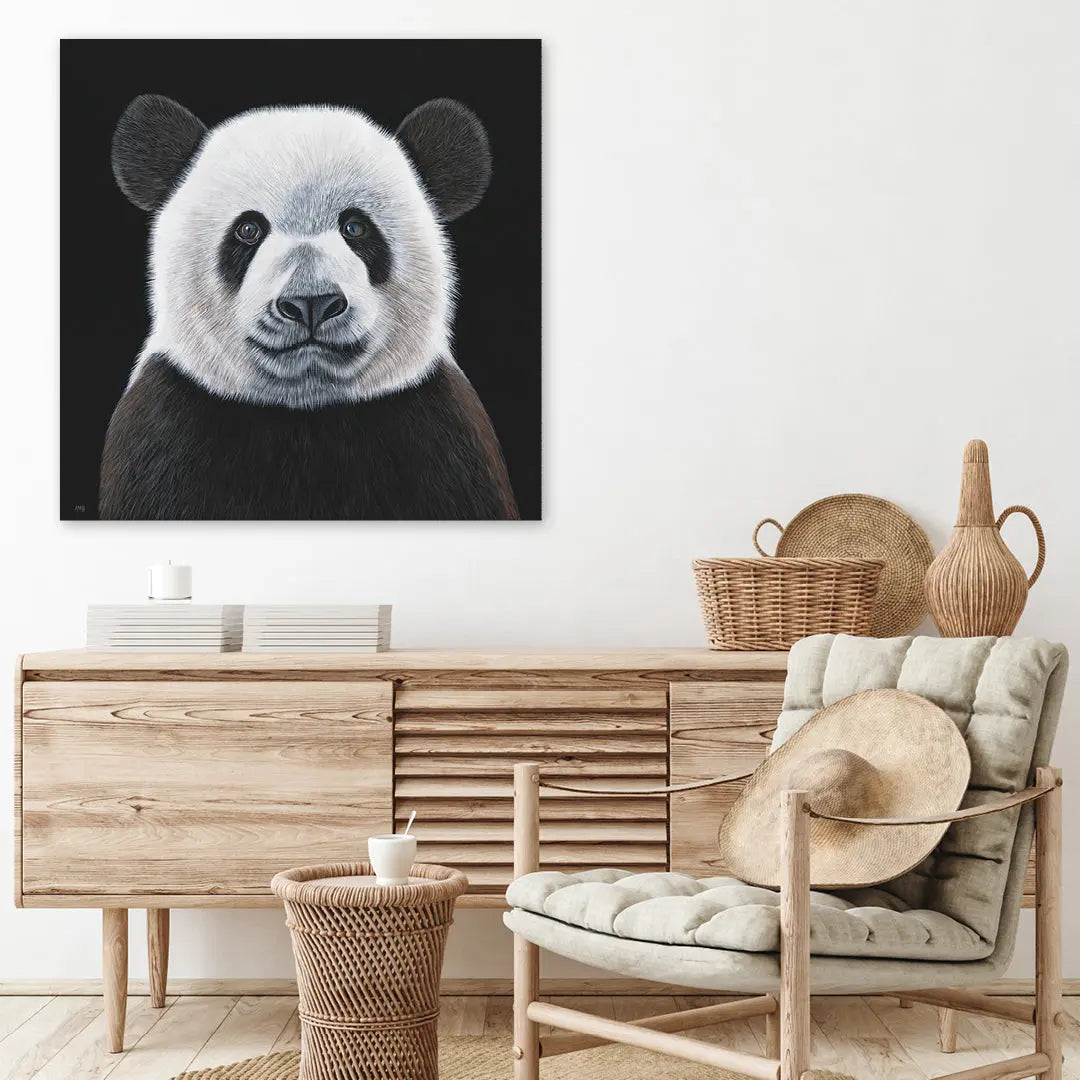 Panda painting on a wall above a wooden console table with decorative items.