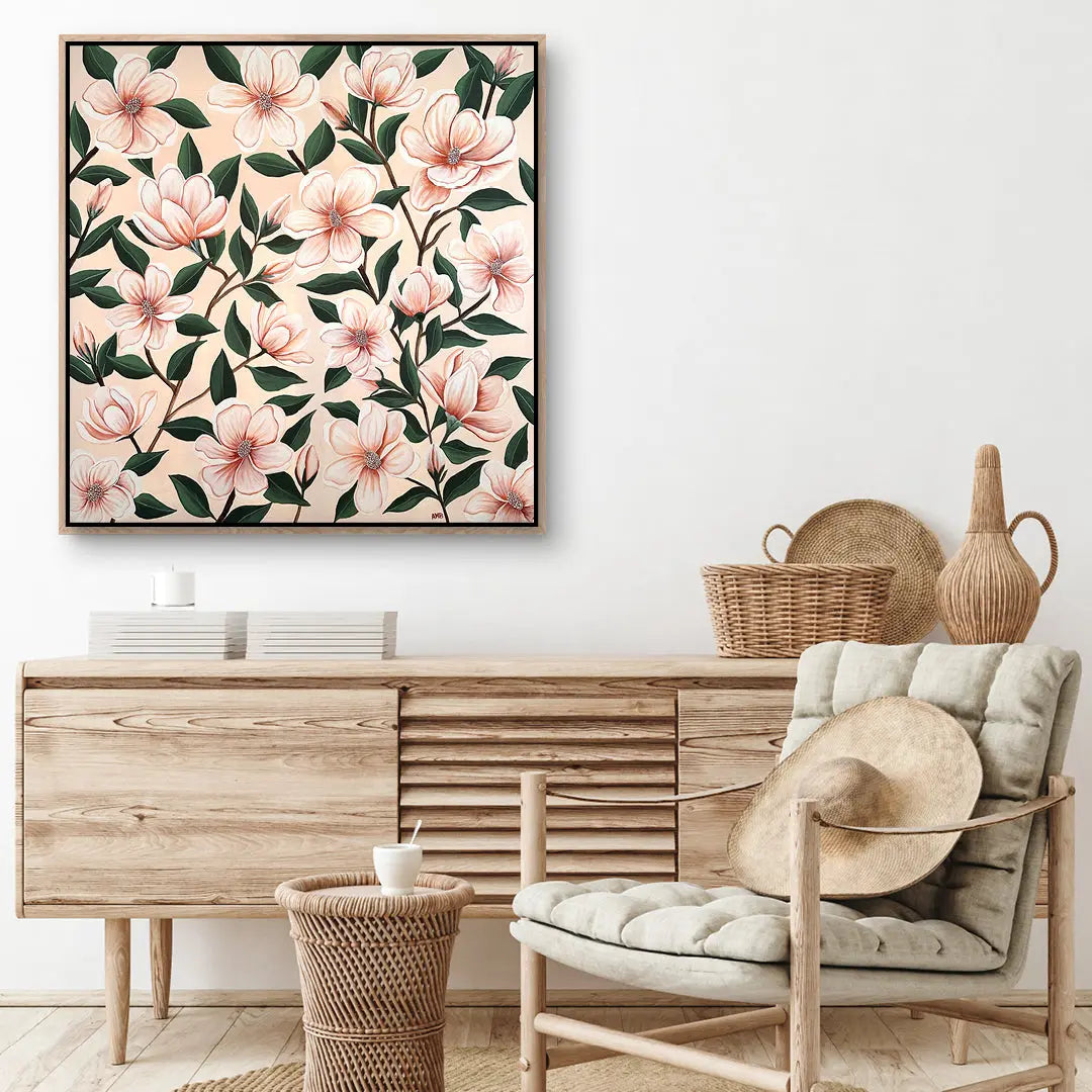 Floral artwork above a wooden sideboard with a chair and decorative items in a room.