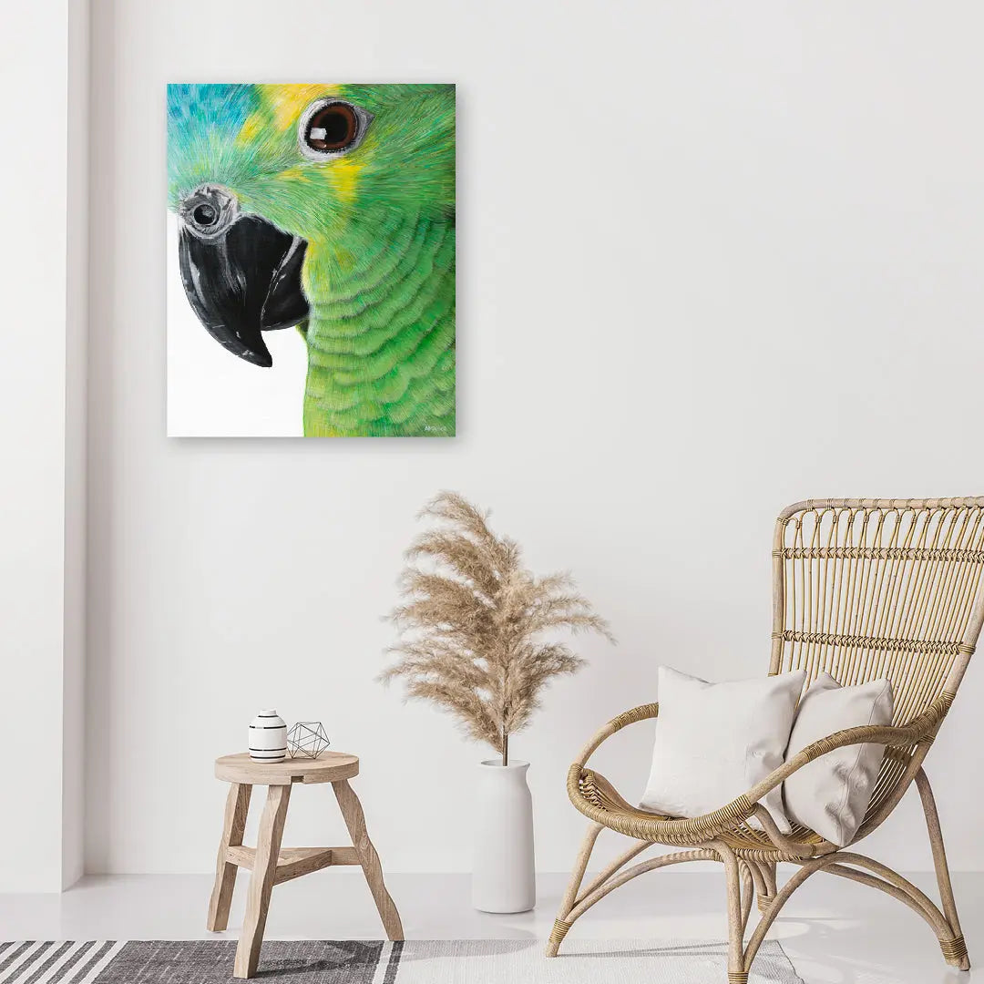 Green parrot painting on a white wall above a wicker chair and small table.