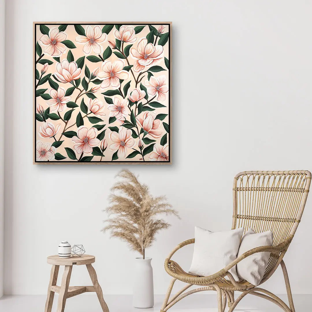 Floral artwork on a wall above a wicker chair and small table.
